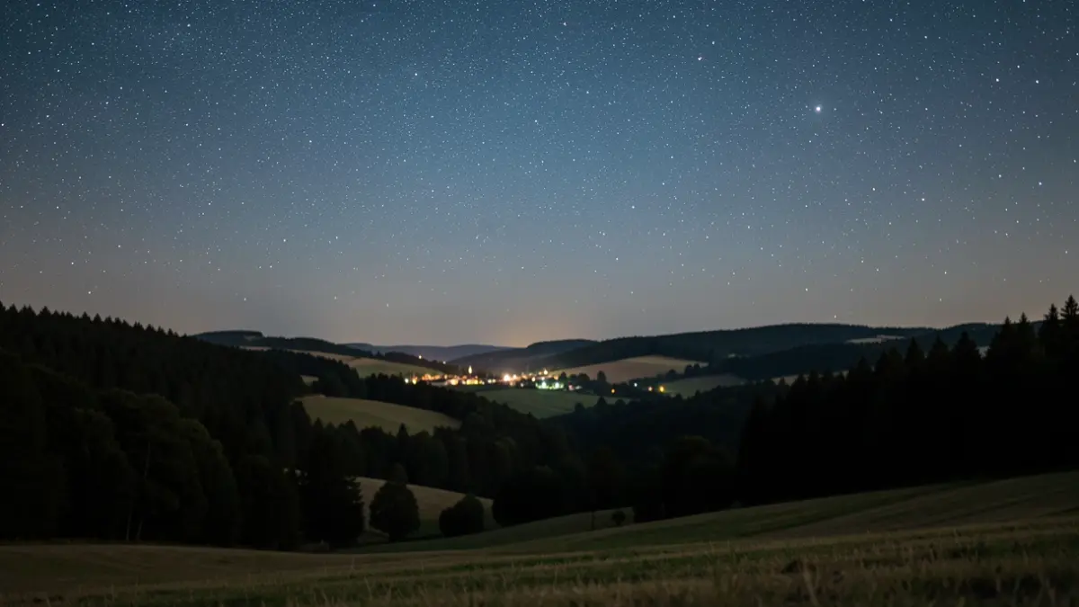 Image générique d'un ciel nocturne étoilé au-dessus d'une campagne française paisible, soulignant la préservation de la nuit.